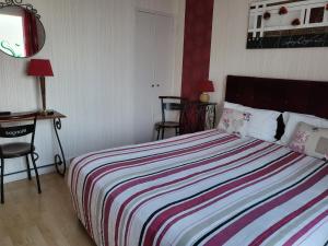 a bedroom with a large bed with a striped blanket at La Sauldraie gîte in Salbris