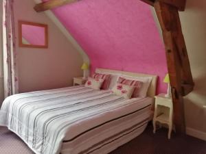 a bedroom with a bed with a pink ceiling at La Sauldraie gîte in Salbris