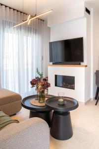 ein Wohnzimmer mit einem schwarzen Couchtisch und einem Fernseher in der Unterkunft Mad Spaces in Volos