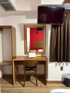 a desk in a room with a mirror and a television at Hotel Jar8 Bule Frente al Mar in Boca del Río