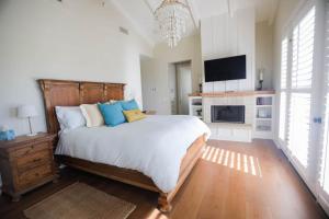 a bedroom with a large bed and a fireplace at Playa Penthouse (Ocean Views) in Carpinteria