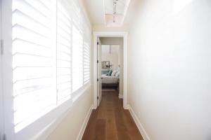 a hallway with white walls and wood floors at Playa Penthouse (Ocean Views) in Carpinteria