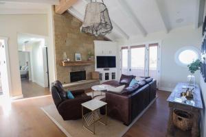 a living room with leather furniture and a fireplace at Playa Penthouse (Ocean Views) in Carpinteria