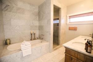 a bathroom with a tub and a sink at Playa Penthouse (Ocean Views) in Carpinteria