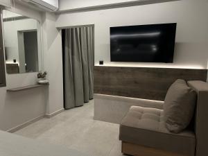 a living room with a couch and a flat screen tv at Aelith Rooms in Platamonas
