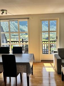 a living room with a table and chairs and windows at Røldal Overnatting in Røldal