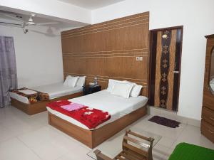 a hotel room with two beds and a chair at HOTEL AL SAFA INTERNATIONAL, Ashkona in Dhaka