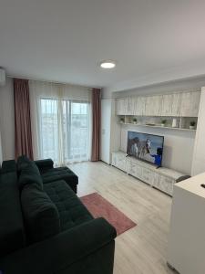 a living room with a couch and a flat screen tv at Apartment in Ploiești 3 in Ploieşti