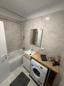 a bathroom with a washing machine and a sink at Apartment in Ploiești 3 in Ploieşti