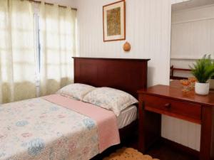 a bedroom with a bed and a dresser and a table at SMITH'S BNB ROOMS in Georgetown