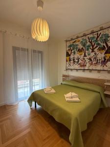 a bedroom with a green bed with two towels on it at La Fenice in Citta' Sant'Angelo