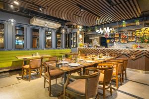 a restaurant with wooden tables and chairs and a bar at Cat Ba Paradise Hotel - Sirocco Sky Bar & Massage in Cat Ba