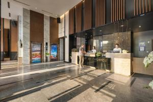 a lobby of a hotel with people standing at a counter at Cat Ba Paradise Hotel - Sirocco Sky Bar & Massage in Cat Ba +113 photos