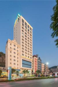 a tall white building in the middle of a city at Cat Ba Paradise Hotel - Sirocco Sky Bar & Massage in Cat Ba