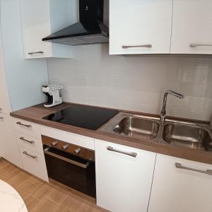 a kitchen with a stainless steel sink and a stove at Appartamento centro storico in Viverone +5 photos