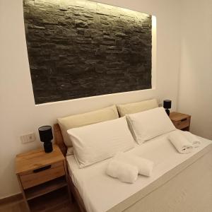 a white bed with two pillows and a painting on the wall at Appartamento centro storico in Viverone