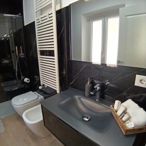 a bathroom with a sink and a toilet and a mirror at Appartamento centro storico in Viverone