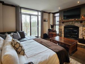a bedroom with a large bed and a fireplace at Tremblant Prestige - BONDURANT 95-10 in Mont-Tremblant
