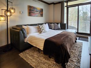 a couch in a living room with a large bed at Tremblant Prestige - BONDURANT 95-10 in Mont-Tremblant