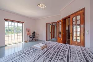 a bedroom with a large bed and a desk at Família de Arega in Arega