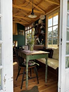 a dining room with a table and a bench at Strackxhoeve Tiny House 'Knalselder' in Laakdal