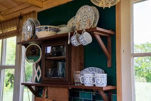 a cabinet filled with plates and dishes on a wall at Strackxhoeve Tiny House 'Knalselder' in Laakdal