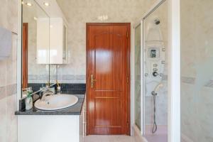 a bathroom with a sink and a wooden door at Família de Arega in Arega +38 photos