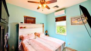 a bedroom with a bed and a ceiling fan at El Palacio Rosa, The Palace in Punta Gorda