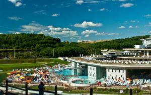 a large swimming pool in front of a building at Astrum Apartman in Egerszalók
