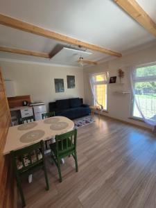 a living room with a table and chairs and a couch at Pod lasem domek letniskowy in Susiec