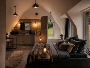a bedroom with a large bed and a kitchen at Bunkier House in Niedźwiada