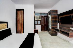a hotel room with a bed and a television at Hotel O A-1 Guest House in New Delhi