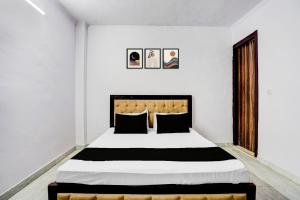 a bedroom with a large bed with black and white sheets at Hotel O A-1 Guest House in New Delhi +25 photos