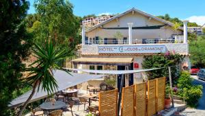 a hotel with tables and chairs in front of a building at Hôtel Le Clos du Dramont in Saint-Raphaël