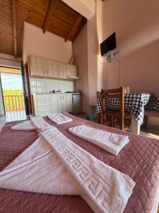 a bedroom with a bed with two towels on it at Ilios Kalamaki in Kalamaki