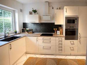 a kitchen with white cabinets and a sink at Haus David in Erfurt