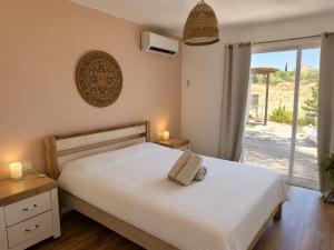 a bedroom with a white bed and a sliding glass door at Moonlight Suite Arad צימר אור הירח, ערד in Arad