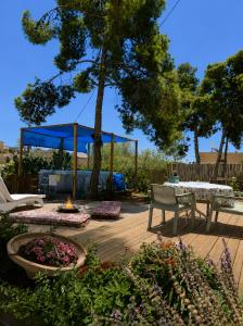 a wooden deck with a fire pit and a blue tent at Moonlight Suite Arad צימר אור הירח, ערד in Arad
