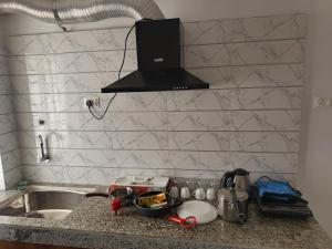 a kitchen counter with a sink and a stove at Purabi homestay in Silchar +34 photos