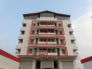 a tall white building with red trim at Purabi homestay in Silchar