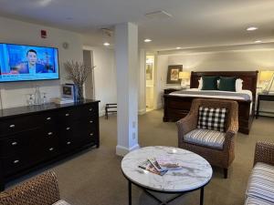 a bedroom with a bed and a tv and a table at OneSixtyFive, The Inn on Park Row in Brunswick