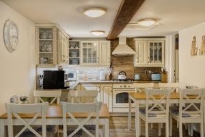 a kitchen with white cabinets and a table and chairs at Chata Vanilka in Bělá pod Pradědem