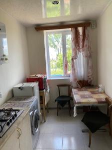 a small kitchen with a stove and a window at Gariks house in Lichkʼ