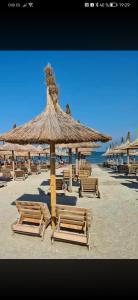 a group of chairs and an umbrella on a beach at Meraki Resort & Spa Isabellae Home in Mamaia Sat/Năvodari