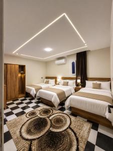 a hotel room with three beds and a checkered floor at GREAT PYRAMIDS View lodge in Cairo