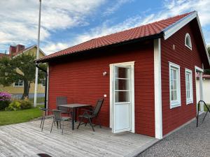 ein roter Schuppen mit einem Tisch und Stühlen auf einer Terrasse in der Unterkunft Hassels hus in Vikingstad
