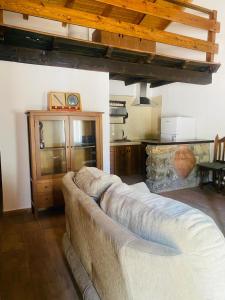 a large couch in a room with a kitchen at Casa El saucar in El Robledo +2 photos