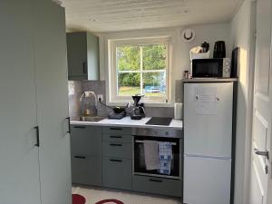 eine Küche mit einem weißen Kühlschrank und einer Spüle in der Unterkunft Hassels hus in Vikingstad