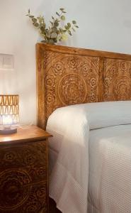 a bed with a wooden headboard next to a table at Casa El saucar in El Robledo