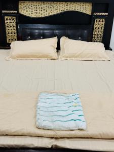 a white bed with a blue towel on it at Sadhana kunj in Varanasi